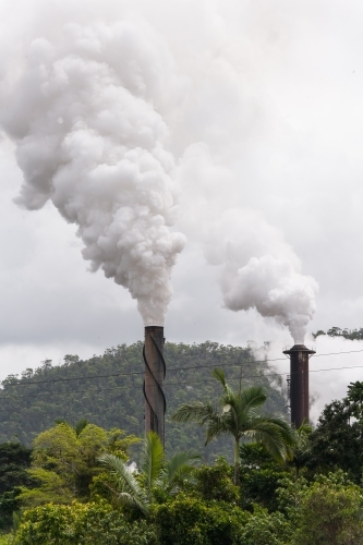 Smoke billowing out of smokestacks at a sugar refinery - Australian Stock Image