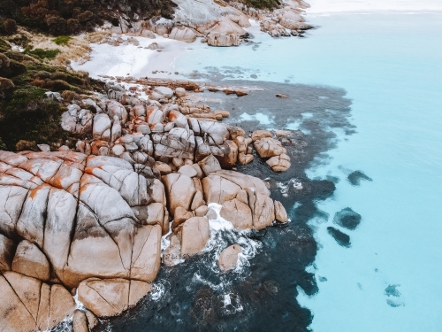 Smooth and rounded rocks along the rocky shoreline. - Australian Stock Image