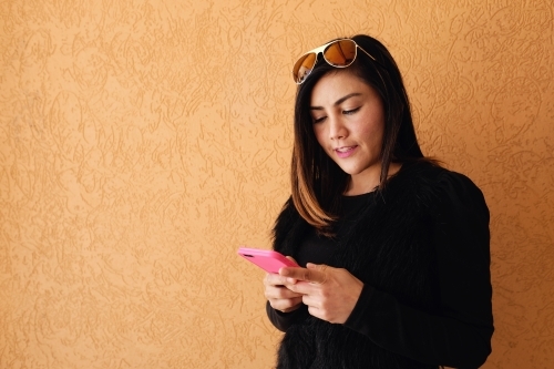 Southeast Asian multicultural woman using mobile phone - Australian Stock Image