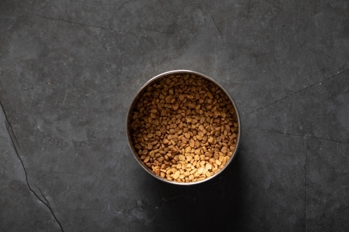 Spice tin of fenugreek seeds top down - Australian Stock Image