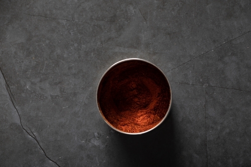 Spice tin of paprika on dark marble background - Australian Stock Image