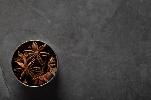 Spice tin of star anise on dark marble background - Australian Stock Image