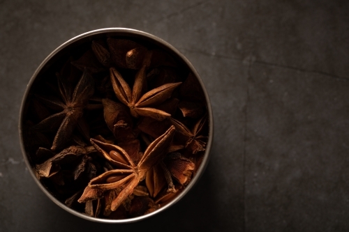 spice tin of star anise on dark marble background - Australian Stock Image