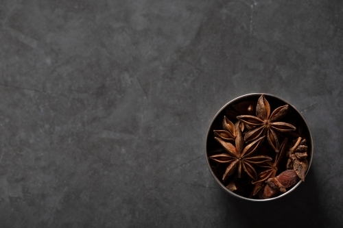 spice tin of star anise on dark marble background - Australian Stock Image