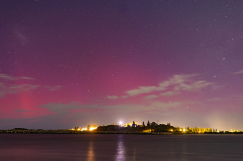 Starry night sky over Yamba NSW with vibrant pink and purple Aurora Australis - Australian Stock Image