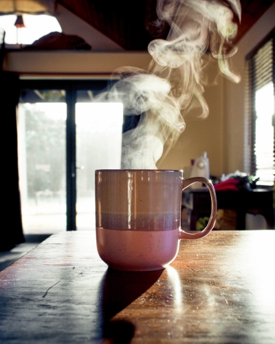 Steam rising from the mug with a hot drink. - Australian Stock Image