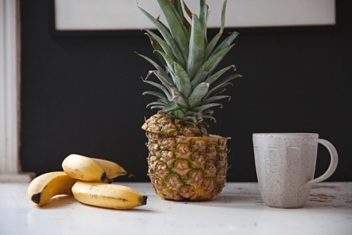 Still life table top in kitchen with bananas and pineapple - Australian Stock Image