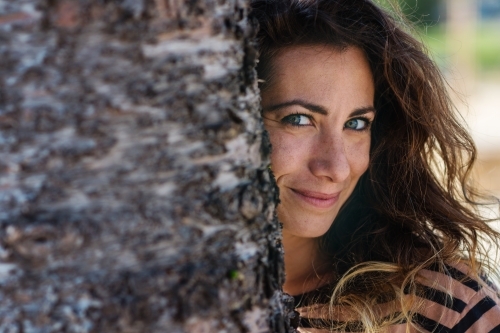 stock photo of woman behind tree - Australian Stock Image