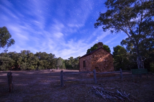 Stone hut and trees at night - Australian Stock Image