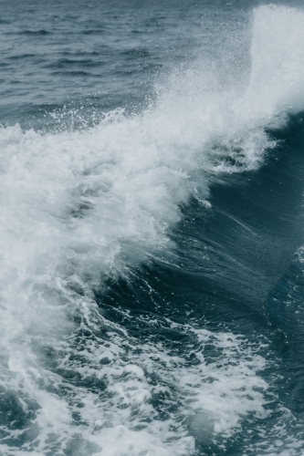 Strong waves with white foam forming on the crests as they break. - Australian Stock Image