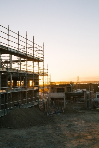 Suburban construction site with machinery and scaffolding, evening sun - Australian Stock Image