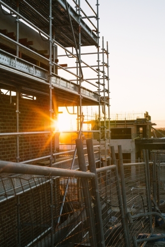 Suburban construction site with machinery and scaffolding, evening sun - Australian Stock Image