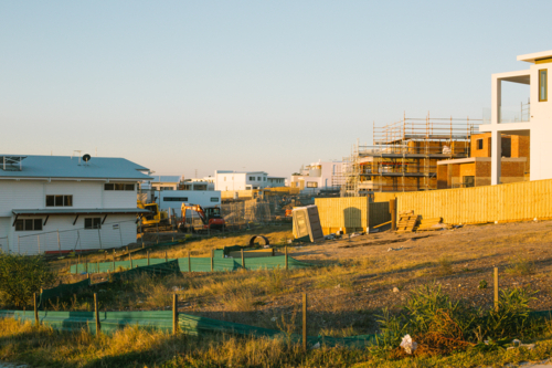 Suburban construction site with machinery and scaffolding, in evening sun - Australian Stock Image