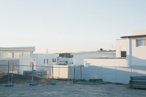 Suburban housing construction site with erected fencing, evening light - Australian Stock Image