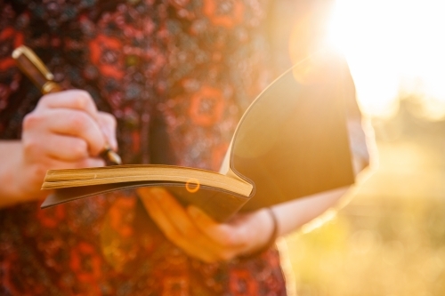 Sun flare over notebook for writing in with fountain pen - Australian Stock Image