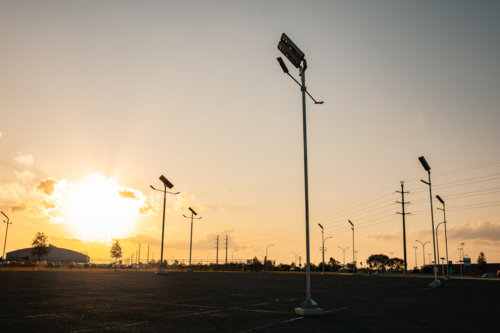 Sun setting over empty car park with solar street lights - Australian Stock Image