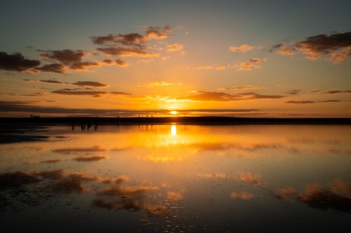 Sun setting over salt lake with reflections on the water - Australian Stock Image