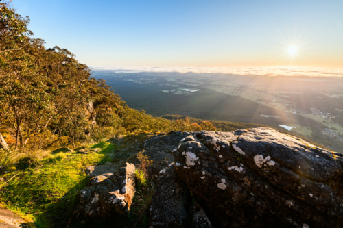 sunrise landscape with boulder in foreground from Boroka Lookout, Grampians, Victoria, Australia - Australian Stock Image