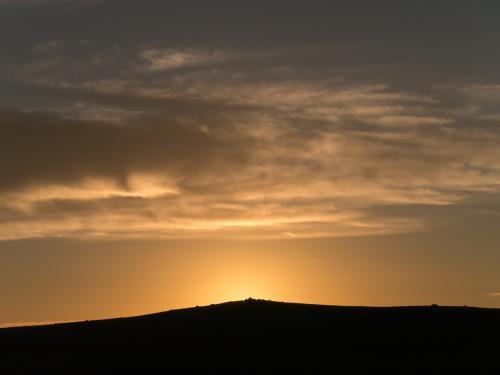 Sunrise over a small hill with light cloud - Australian Stock Image