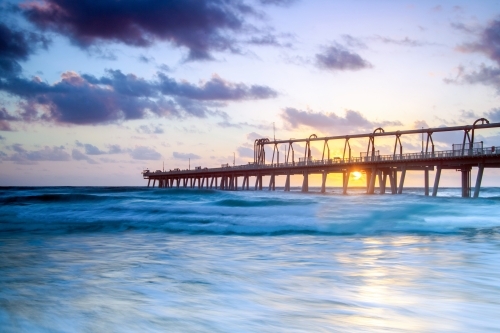 Sunrise through the pier at The Spit in the Gold Coast - Australian Stock Image