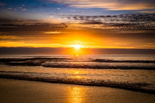 sunrise at the beach with orange skies - Australian Stock Image