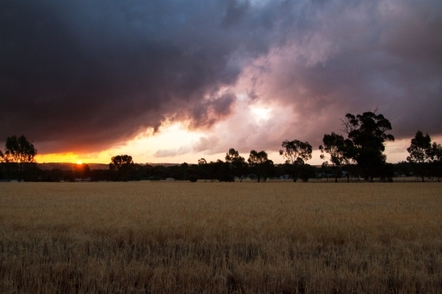 sunset through gap in storm clouds - Australian Stock Image