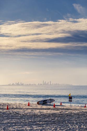 Surf Life Saving board on beach with city in background - Australian Stock Image