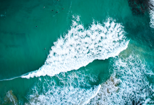 Surfers allow underdeveloped waves to pass. - Australian Stock Image