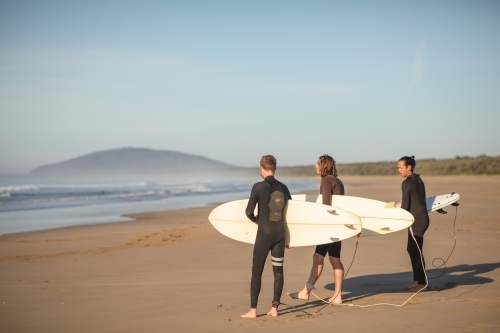 Surfers walking towards ocean - Australian Stock Image