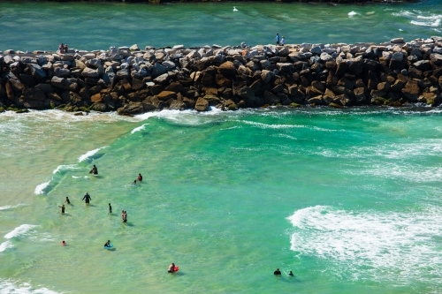 Swimmers and people spending time around the surf beach and mouth of the Evans River of Evans Head. - Australian Stock Image