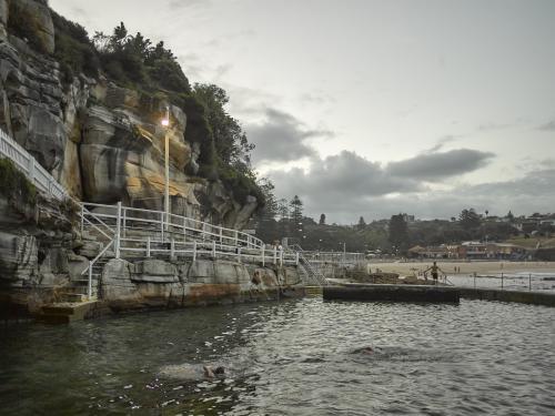 Swimmers at Bronte Ocean Pool at dusk - Australian Stock Image