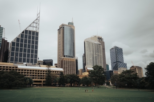 Sydney CBD skyline with people playing on the grass in the Royal Botanic Gardens - Australian Stock Image