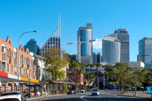 Sydney city skyline from Woolloomooloo with road and shops in foreground