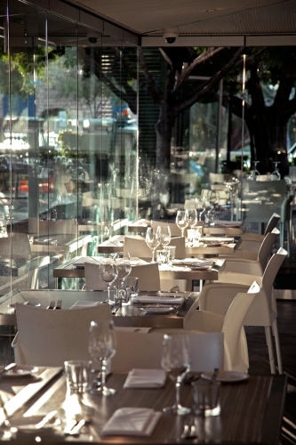 Table settings inside a restaurant with glass walls - Australian Stock Image