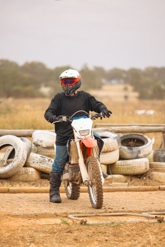 Teen boy riding motorbike at motocross track meet - Australian Stock Image