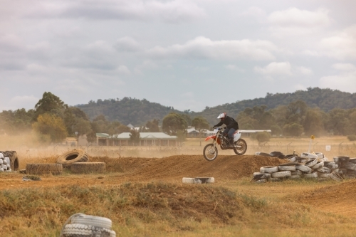 Teen boy riding motorbike at motocross track meet - Australian Stock Image