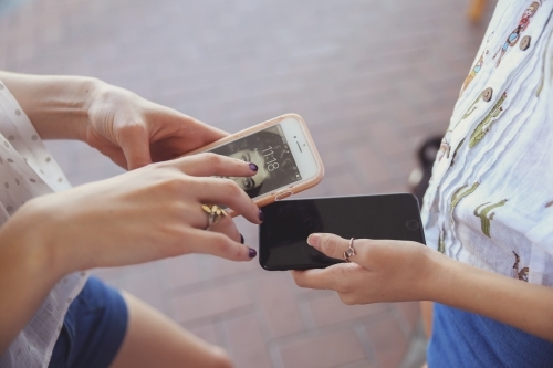 Teen girls using mobile phones - Australian Stock Image