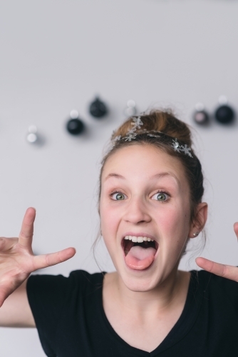 teen with hair bun and snowflakes making silly faces - Australian Stock Image