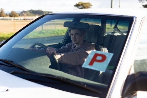 Teenage boy in vehicle looking through windscreen - Australian Stock Image