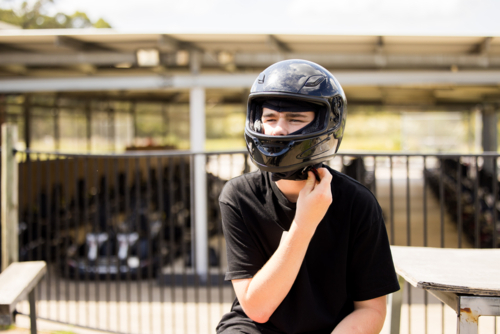 Teenage boy wearing helmet ready for go-kart race - Australian Stock Image
