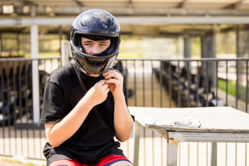Teenage boy wearing helmet ready for go-kart race - Australian Stock Image