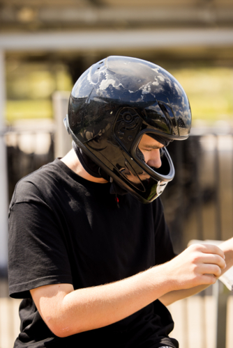 Teenage boy wearing helmet ready for go-kart race - Australian Stock Image