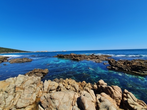 Teenage girl floating in an ocean rock pool - Australian Stock Image