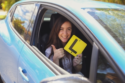 Teenage girl holding L plate - Australian Stock Image