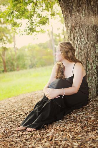 Teenage girl sitting under a tree - Australian Stock Image