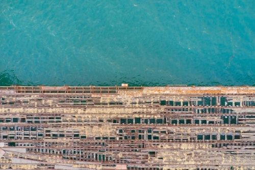 The contrast of a derelict jetty falling to pieces and the crystal clear turquoise ocean water. - Australian Stock Image