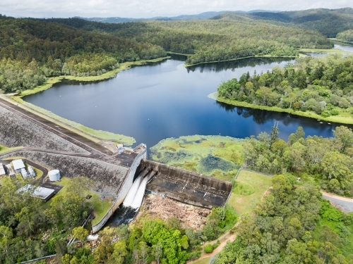 The Enoggera Reservoir, with flowing spillway, in the Brisbane suburb of The Gap - Australian Stock Image