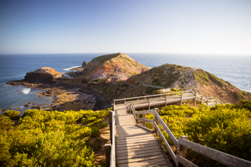 The famous Cape Schanck boardwalk runs towards the sea and rock formation known as London Bridge - Australian Stock Image