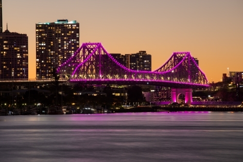 The Story Bridge illuminated magenta/pink after the sun has set