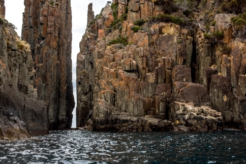 The towering cliffs of Cape Hauy in Tasmania seen from the water - Australian Stock Image